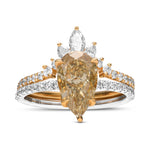 An engagement and wedding ring set featuring a pear-shaped fancy brownish yellow diamond with round brilliant cut side stones set in 18K white and yellow gold.