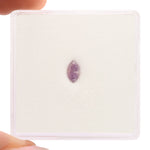 Purple amethyst crystal on a white card held by a hand