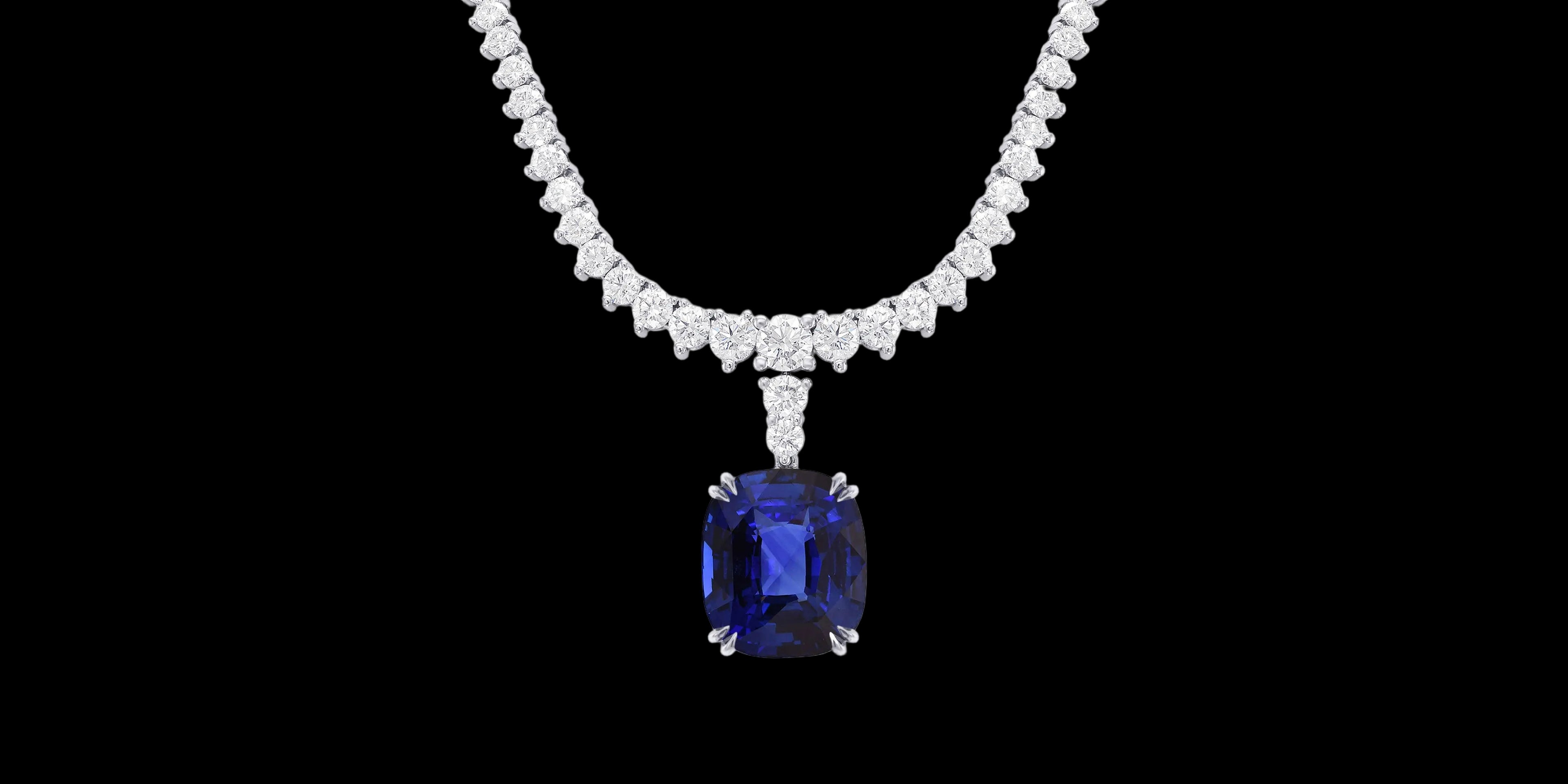 Diamond necklace with a blue gemstone pendant on a black background